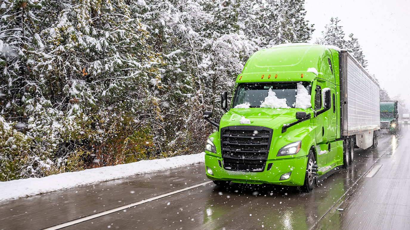A semi truck driving in snowy weather