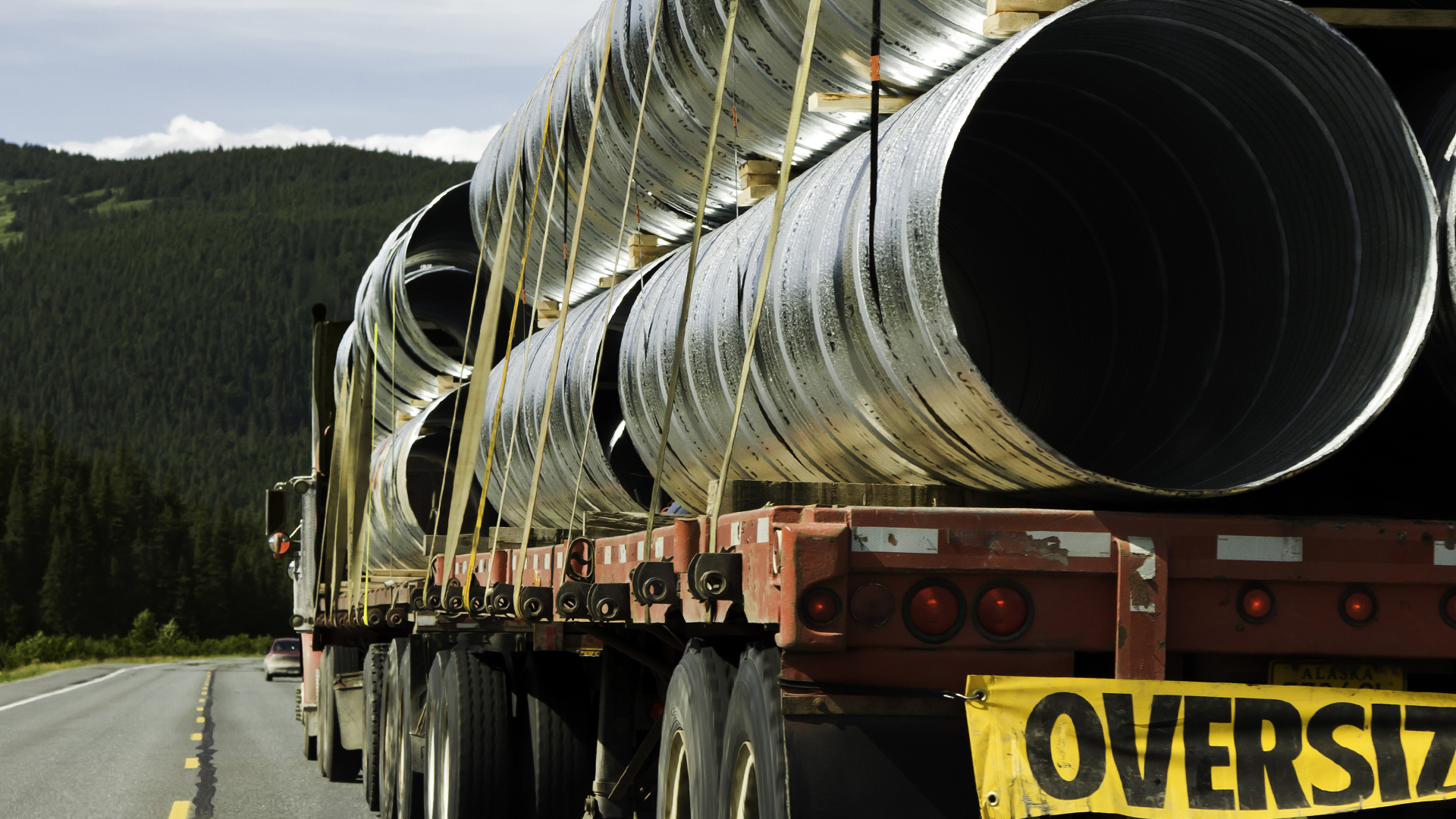 Semi truck with an Oversized flatbed load on a highway