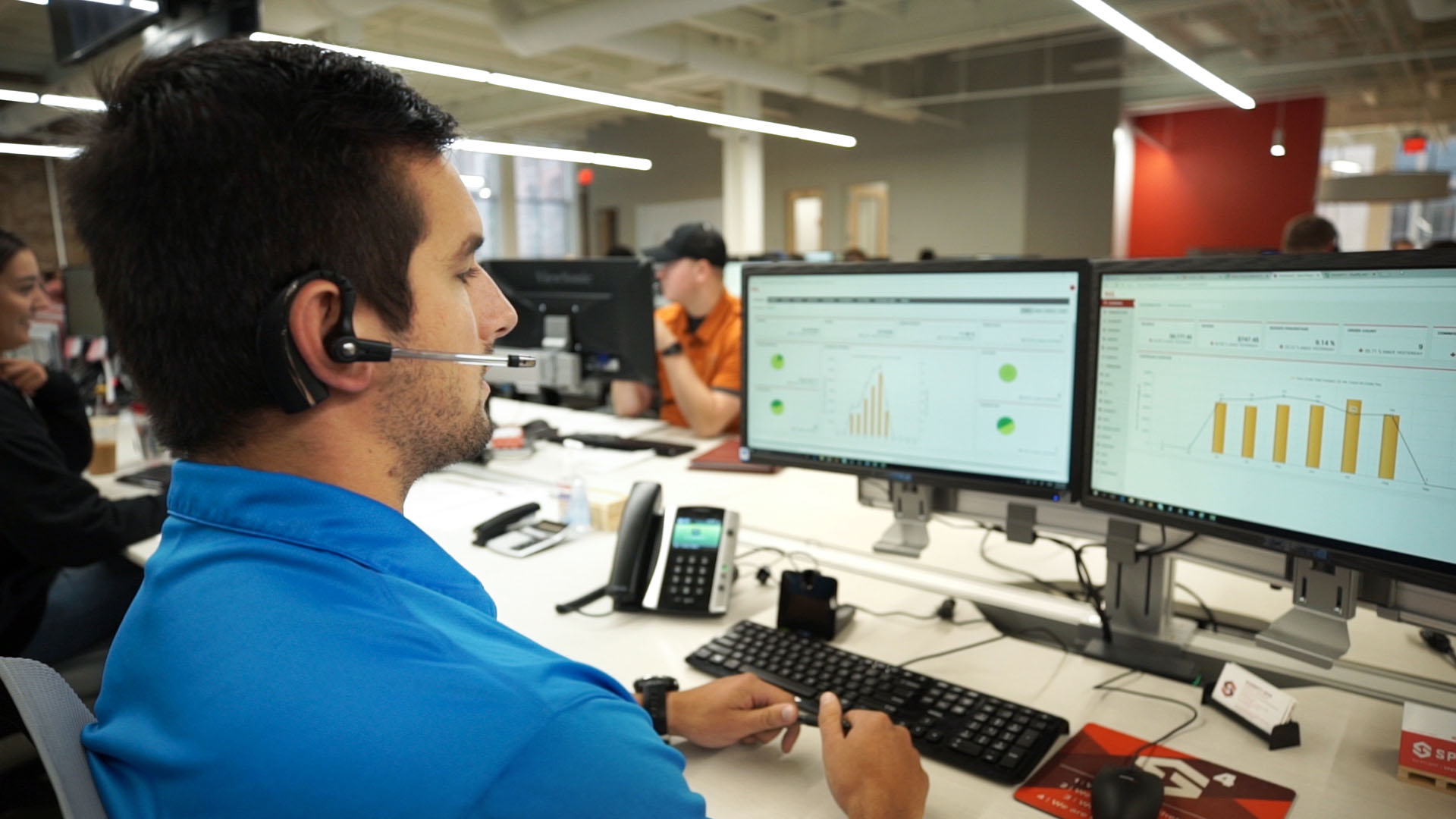 MySpot employee looking at TMS analytics data talking to a shipper, logistics, driver or carrier pro on a headset phone