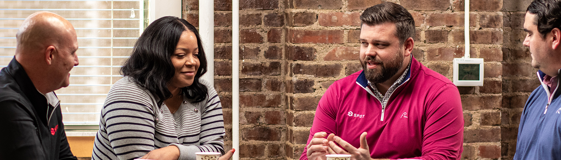 Four Spot employees sitting around a table discussing how to better serve its shippers and customers.