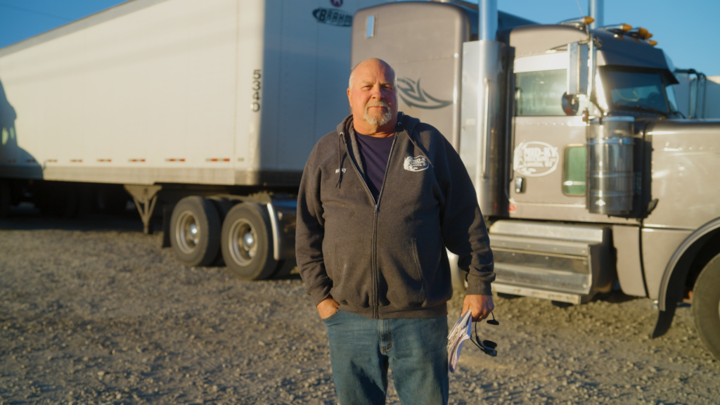 Mid-KY Trucking owner Ricky Brahm posing in front of one of his semi trucks