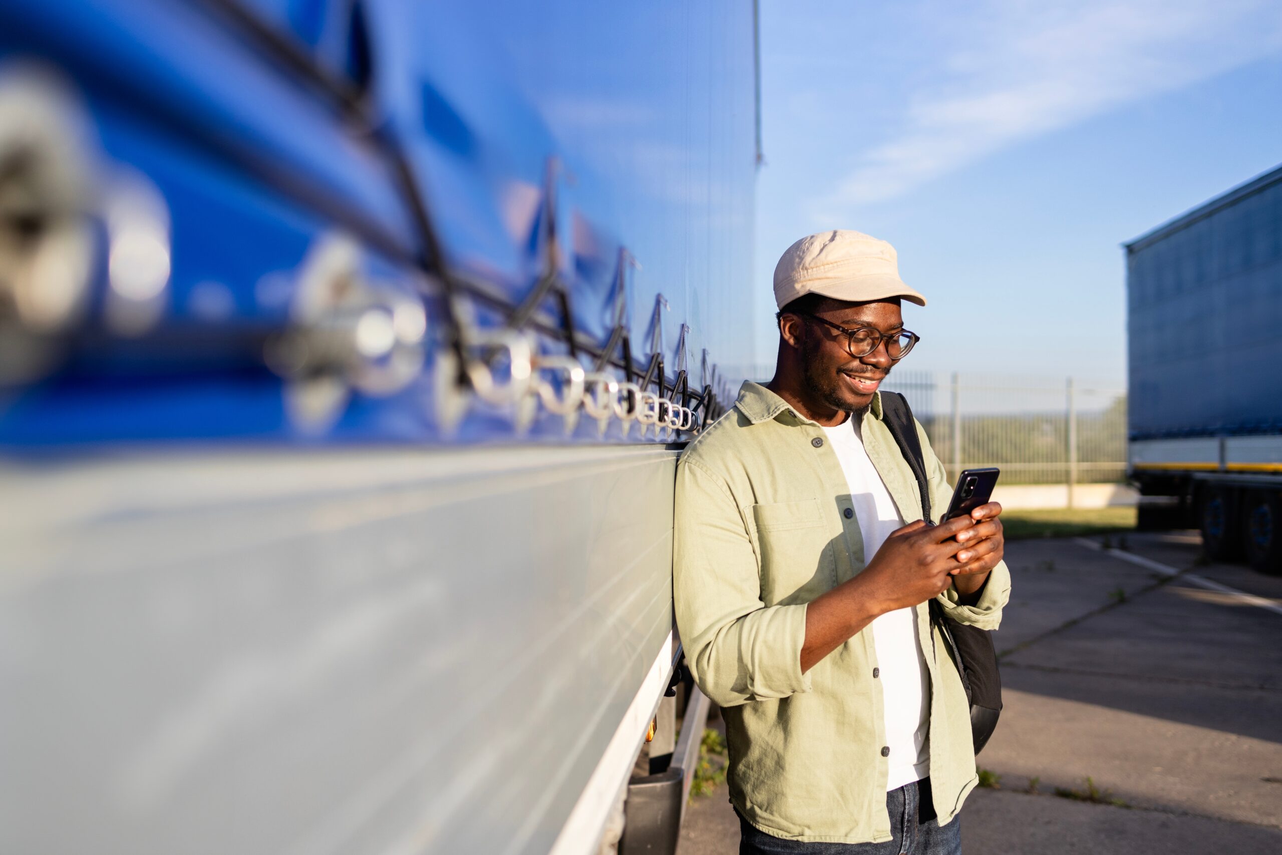 Driver,Standing,By,His,Truck,And,Using,Mobile,Phone.